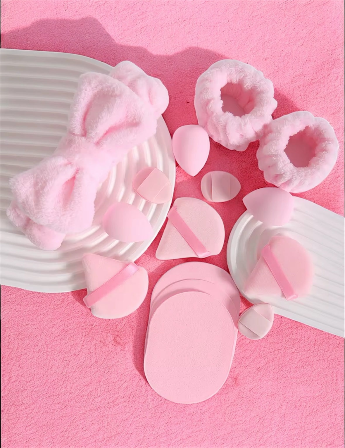 Pink bath bombs and sponges on a pink background