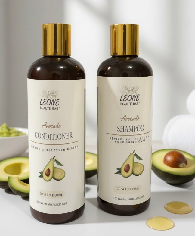 Two bottles of Leone Beaute Bar Avocado Shampoo and Conditioner on a light background with avocados.