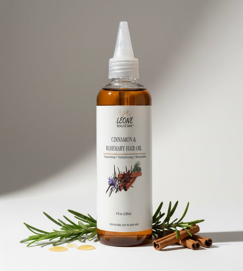 Bottle of Leone Cinnamon & Rosemary Hair Oil with ingredients on a neutral background