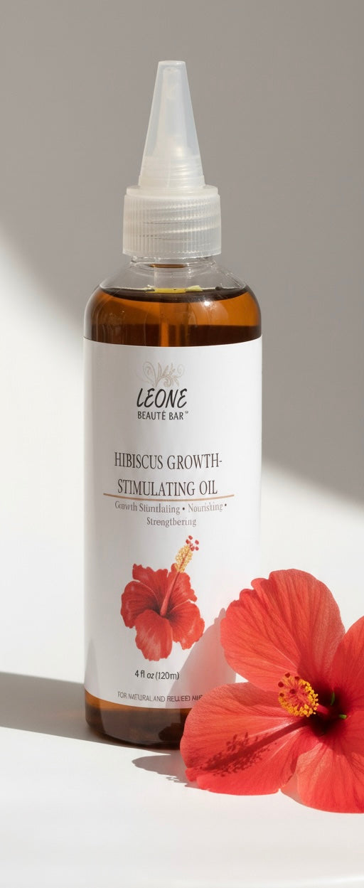 Bottle of Leone Hair Growth Stimulating Oil with a hibiscus flower on a white background